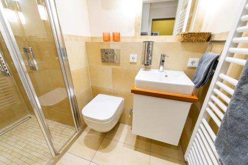 ein Bad mit einem WC, einem Waschbecken und einer Dusche in der Unterkunft Villa Marina - Weitblick aufs Meer in Wangerooge