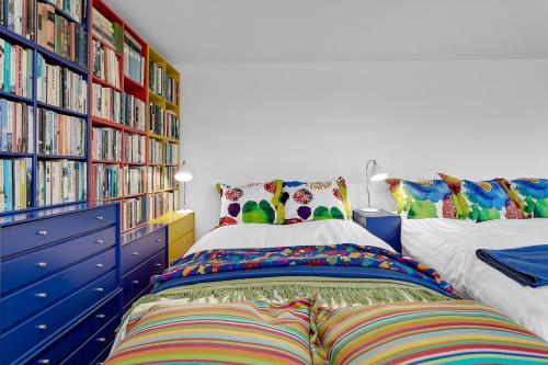 a bedroom with a bed and bookshelves filled with books at SK52 by the Sea, Unique spacious luxury, HG-17071 in Reykjavík