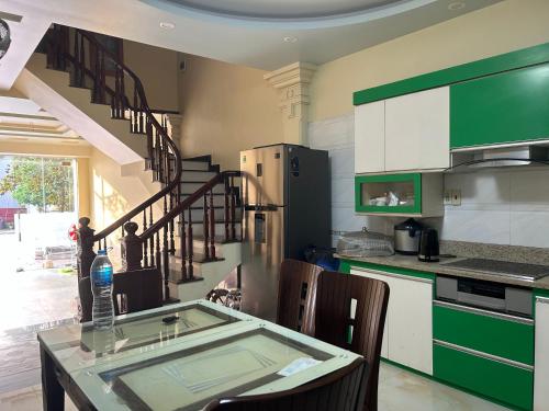 una cocina con armarios verdes y una mesa con sillas en S23 homestay en Hai Phong