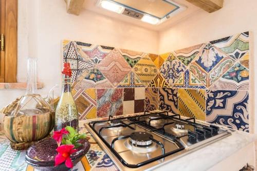 a kitchen with a stove and a mosaic wall at 2 bedrooms appartement with shared pool jacuzzi and wifi at Bottega Genovini in Sorrezzana