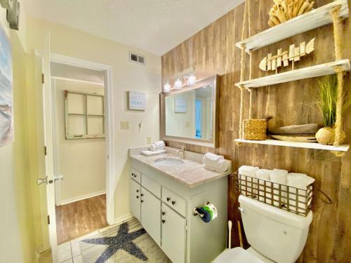een badkamer met een toilet, een wastafel en een spiegel bij Sundial 2C by ALBVR - Great Views - Great Location and Amenities in Gulf Shores