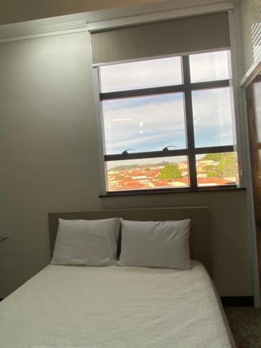 a bedroom with a bed and a window at Apart Hotel Seg Total Lofts Encantadores in Mogi-Guaçu