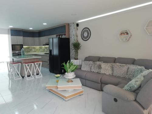 ein Wohnzimmer mit einem Sofa und einer Küche in der Unterkunft ALAMEDA MI DESCANSO in Carmen de Viboral