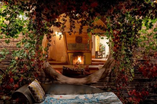 a room with a couch and a fireplace with plants at Hotel Altiplanico Cajón del Maipo in San José de Maipo