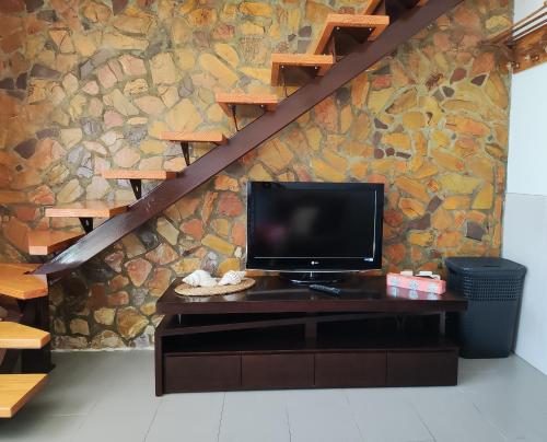 TV sentada en un escritorio frente a una pared de piedra en Casa Azul, en Albufeira