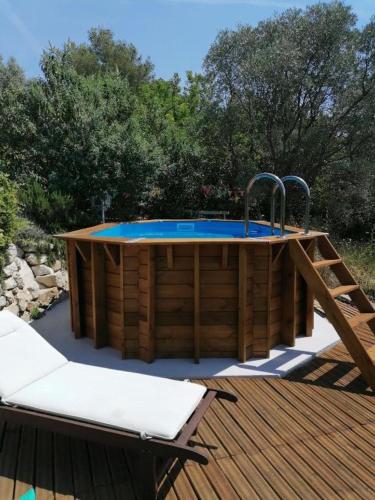 a wooden deck with a hot tub on top of it at Bastide Provençale Les Mûriers d'Engaspaty in Seillans