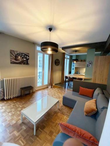 un salon avec un canapé et une table dans l'établissement Les Quatre Piliers - 1 min Palais Jacques Cœur, à Bourges