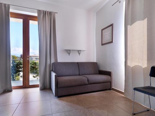 a living room with a couch and a sliding glass door at Residence Il Melograno in Manerba del Garda