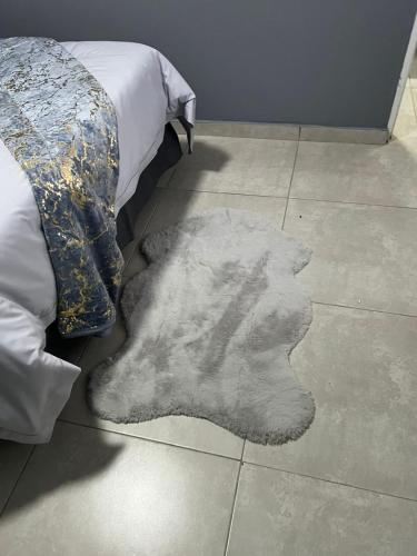 a rug laying on the floor next to a bed at Ubuntu Lifestyle Estate - Nkandla DeLux in Krugersdorp