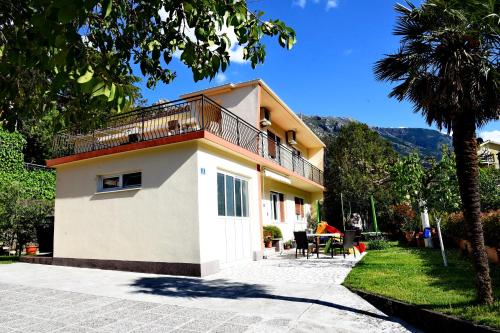 a house with a balcony on top of it at Apartmani F&M in Kotor