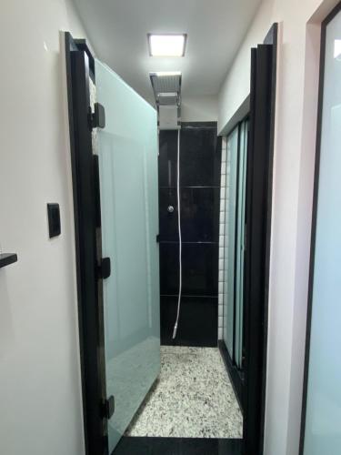 a bathroom with a walk in shower and a mirror at Apart Hotel Seg Total Lofts Encantadores in Mogi-Guaçu