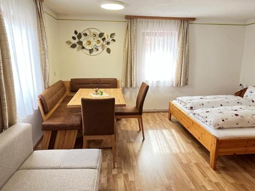 Habitación con cama, mesa y sofá en Hotel Gasthof Seeblick en Zeutschach