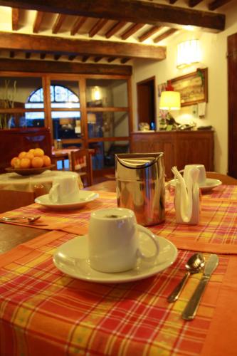 a table with plates and cups on top of it at BeB Reboglio in Rolo