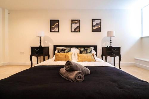 a bedroom with a large black bed with two night stands at Camber Hill - Long Stay Offer in London