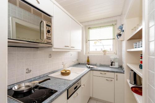 - une cuisine avec des placards blancs et un évier dans l'établissement Meeresrauschen, à Westerland