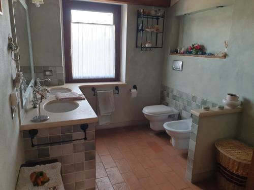 a bathroom with a sink and a toilet and a window at La Fornace in Rapolano Terme
