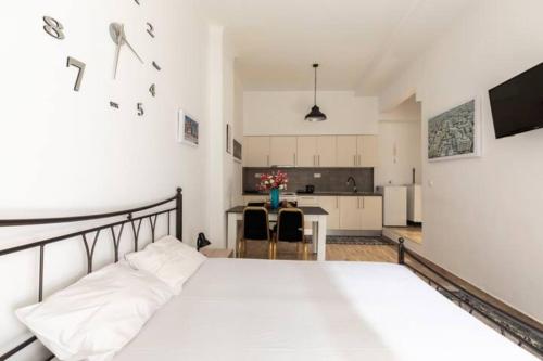 een slaapkamer met een groot wit bed en een keuken bij Perfect Apartment 71B in Thessaloniki