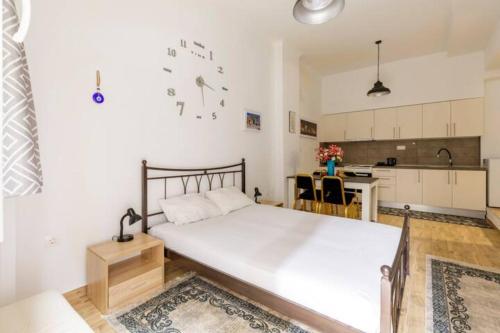 een slaapkamer met een groot wit bed en een keuken bij Perfect Apartment 71B in Thessaloniki