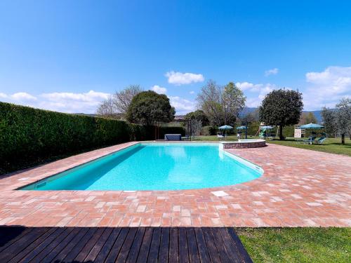 a swimming pool in a yard with a brick patio at Residence Il Melograno in Manerba del Garda