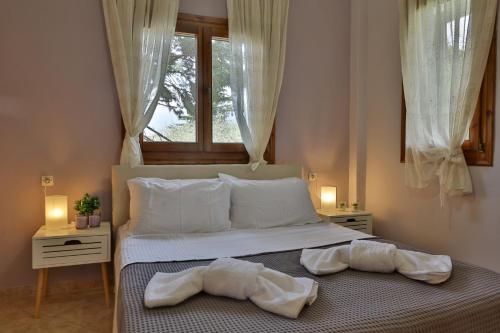 a bedroom with two towels on a bed with a window at ZeusPlace Olympus Olive Country House 4 in Leptokaria