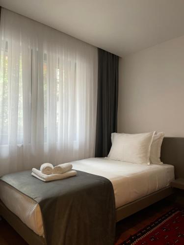 Etnomania Boutique Hotel في بريشتيني: غرفة فندق عليها سرير وفوط