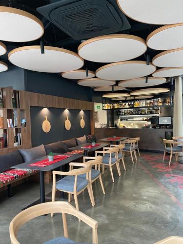 a dining room with tables and chairs and lights at Etnomania Boutique Hotel in Pristina