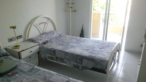 a bedroom with two beds and a nightstand with a bed sidx sidx sidx sidx at 3 bedrooms apartement with sea view shared pool and furnished garden at Aguilas in Águilas
