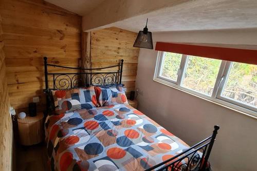 1 dormitorio con 1 cama en una cabaña de madera en The Wendy house, en Parkend