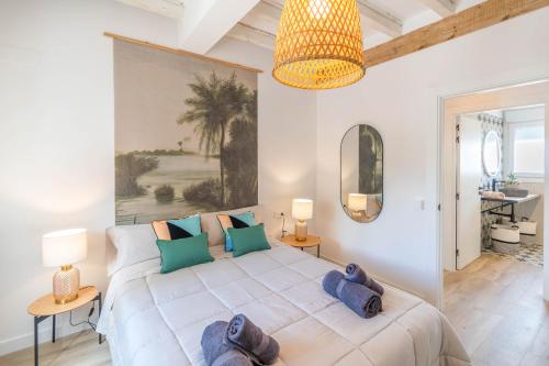 sypialnia z dużym białym łóżkiem z niebieskimi poduszkami w obiekcie Casa Bardena Negra, cómodo alojamiento para visitar las Bardenas y Sendaviva w mieście Fustiñana