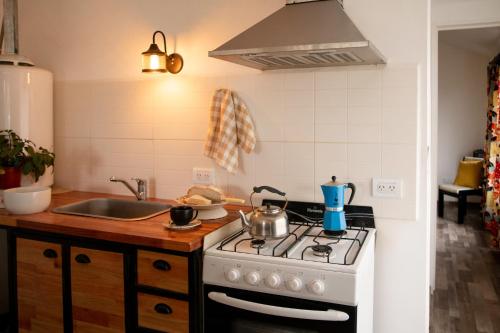 Una cocina con una estufa blanca y un fregadero. en Luma Esquel, en Esquel