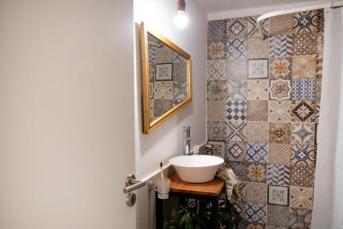 baño con lavabo y pared de mosaico en Luma Esquel, en Esquel