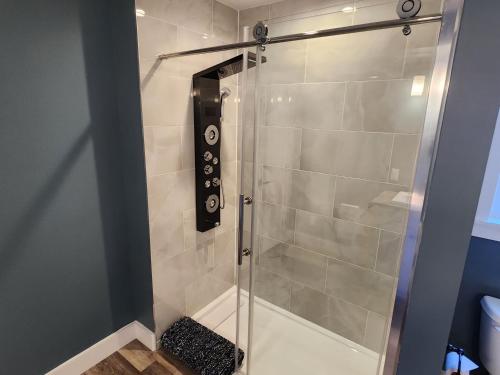 a shower with a glass door in a bathroom at Captain Dan's Cozy in Saint Andrews