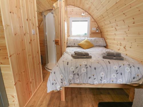 a bedroom with a bed in a wooden cabin at Parys Pod in Bodewryd