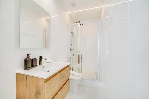 a white bathroom with a sink and a shower at Vila Lopes in Lisbon