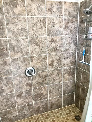 a bathroom with a shower with a tile wall at Sea Haven - Sea View at Symphony Beach Club in Ormond Beach