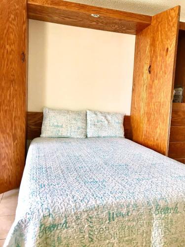 a bed with a wooden headboard in a bedroom at Sea Haven - Sea View at Symphony Beach Club in Ormond Beach
