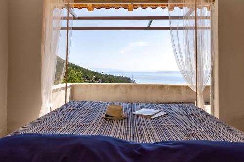 a bedroom with a bed with a hat and a window at Villa Rita in Makarska