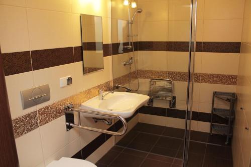 a bathroom with a sink and a shower at Karla, apartamenty i pokoje w Dębkach in Dębki