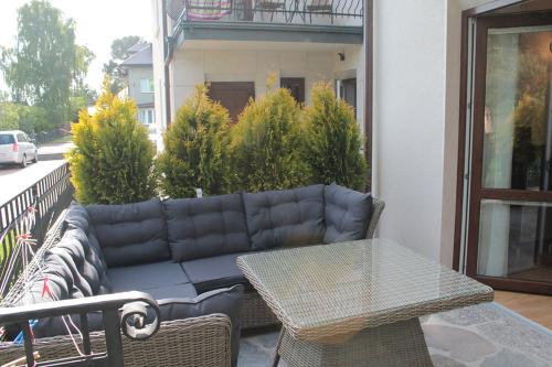a couch sitting on a balcony with a table at Karla, apartamenty i pokoje w Dębkach in Dębki