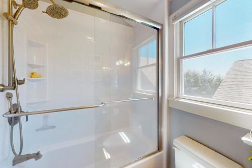 a glass shower in a bathroom with a window at Beech Tree Retreat in Provincetown