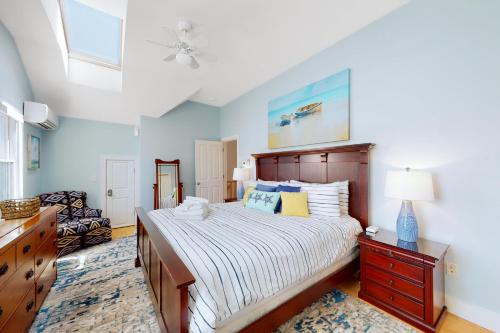 a bedroom with a bed and a dresser and a ceiling at Beech Tree Retreat in Provincetown