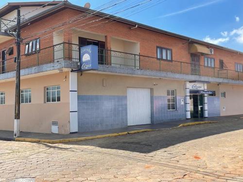 a brick building with a balcony on a street at Pousada Cabana in Avaré