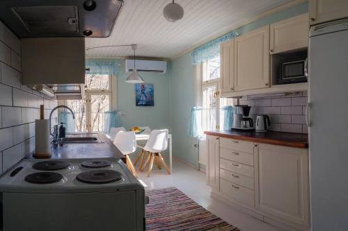 a kitchen with a sink and a stove top oven at Villa Moisio - puutaloidylliä Salon keskustassa in Salo