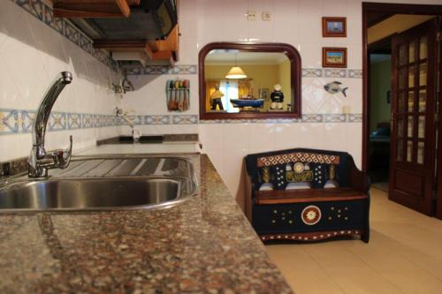 een keuken met een wastafel en een spiegel bij One bedroom apartement with city view balcony and wifi at Gafanha da Nazare in Gafanha da Nazaré