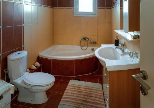 La salle de bains est pourvue de toilettes, d'une baignoire et d'un lavabo. dans l'établissement BRILLIANT HOUSE, à Vólos