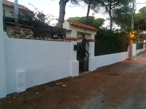 a white fence in front of a house at Charming Villa in Punta Umbría with Private Pool in Punta Umbría
