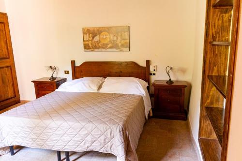 a bedroom with a large bed and two night stands at Podere Mezzastrada - Place of Charme in Fiano