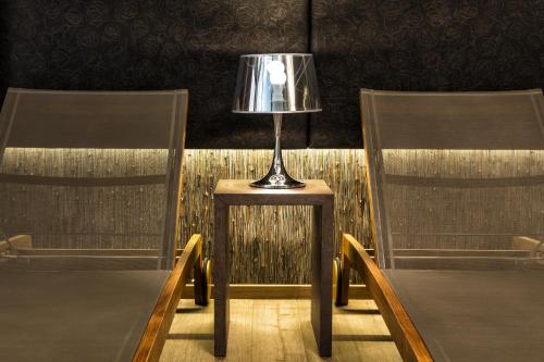 a lamp on a table in between two chairs at Hotel Ideal Park in Laives