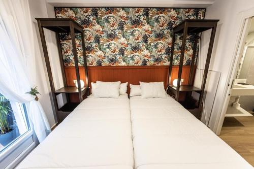 a bed in a room with a floral wallpaper at Hospedaxe Memorias de Sophia in Fisterra