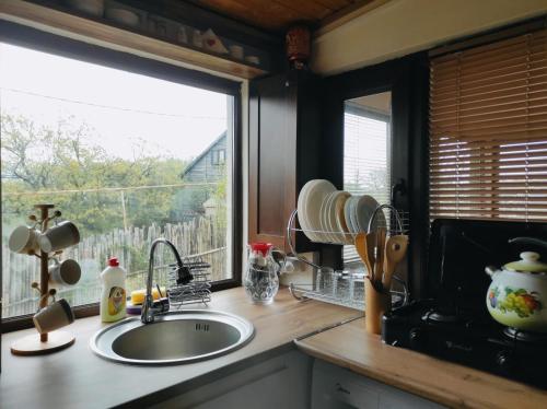 um balcão de cozinha com um lavatório e uma janela em Kikety Paradise em Kiketʼi